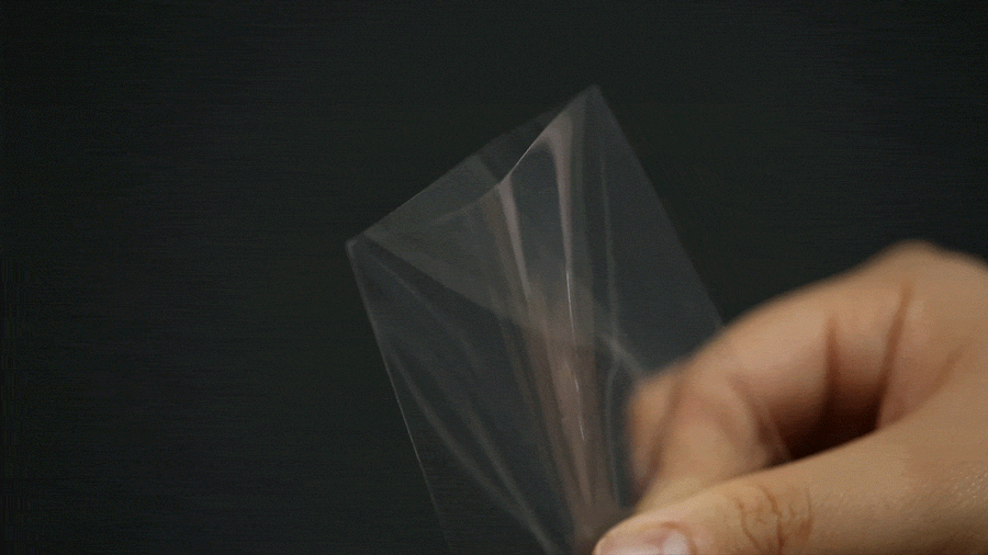 Flexible PVC-free clear photocard sleeve being twisted to show its premium durable material